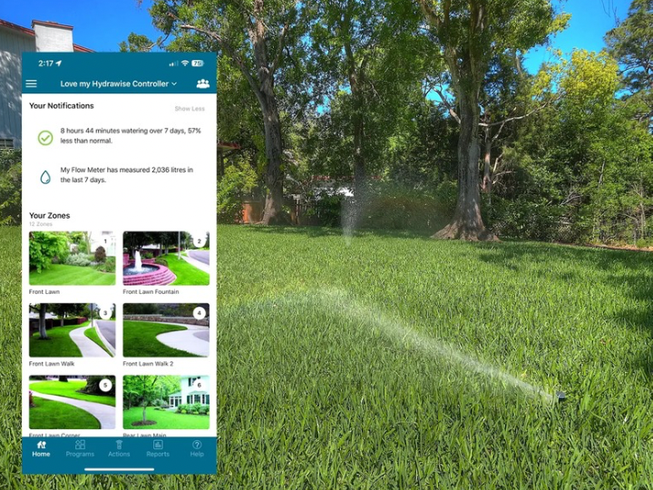 Smart irrigation controller app beside an operating lawn sprinkler system